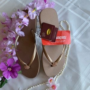 Rose Gold Havaianas flip flops with flower charm. Size 7 1/2 and Brand New.